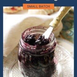 a small jar of blueberry jam on a table.