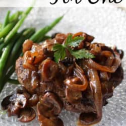 salisbury steak with mushrooms and onions on a clear plate.