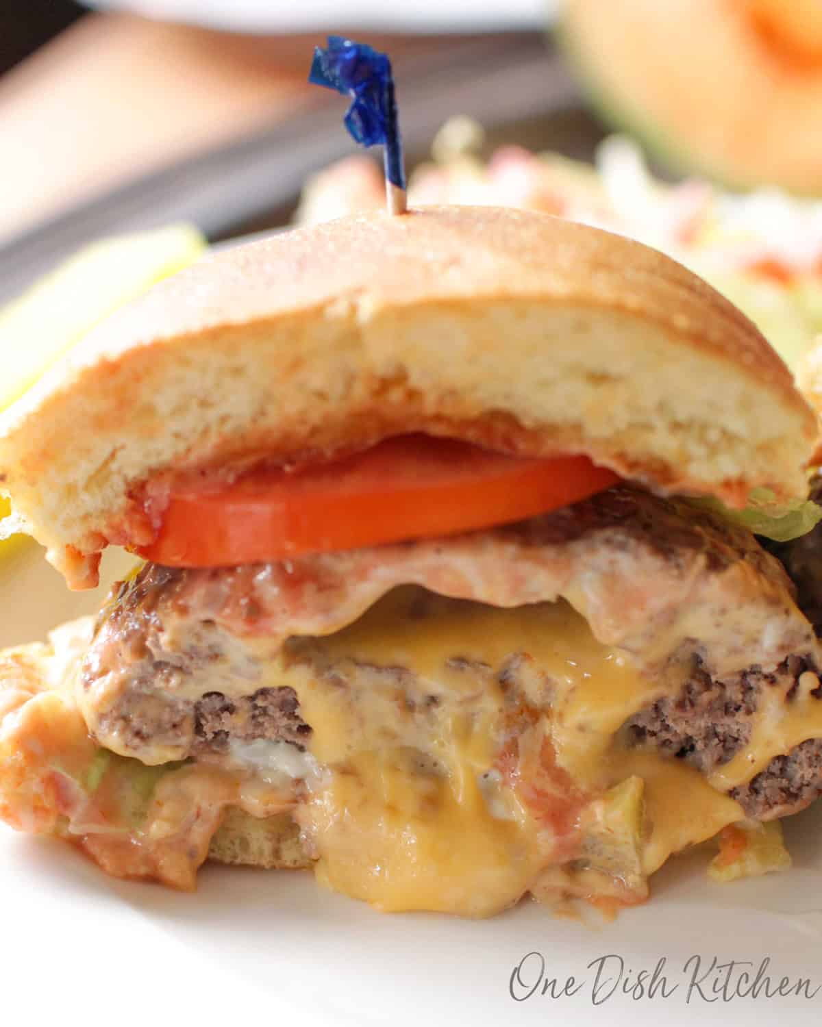a juicy lucy sliced in half with melted cheese.