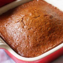 a mini gingerbread loaf in a red baking dish.
