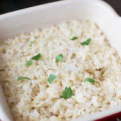 rice in a red baking dish topped with parsley.