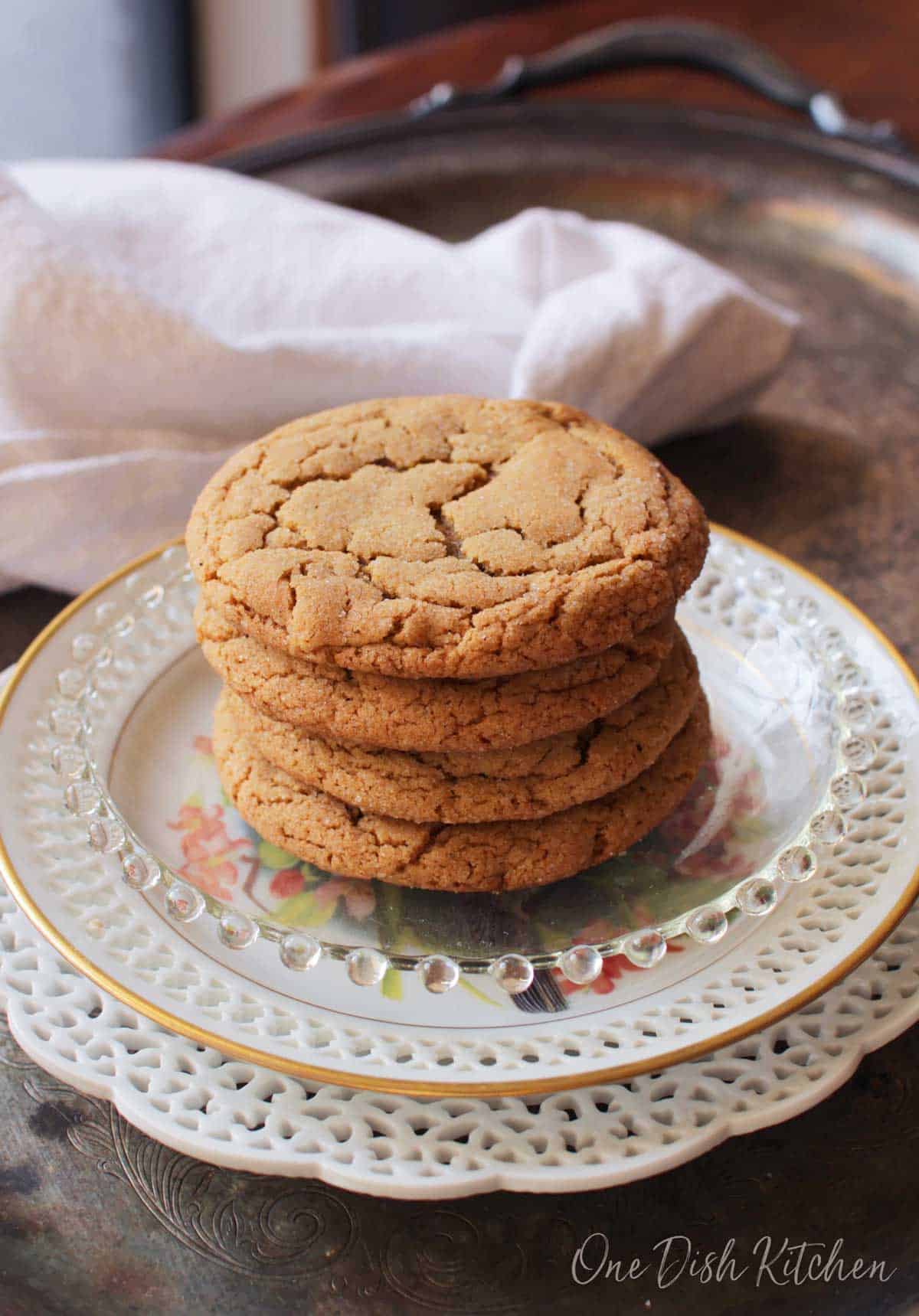 A stack of four soft ginger cookies plated on a metal tray.