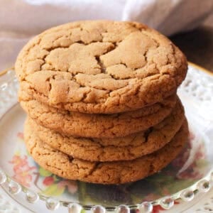 four ginger cookies stacked on a plate.