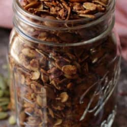 a close up of a jar of granola on a silver tray.