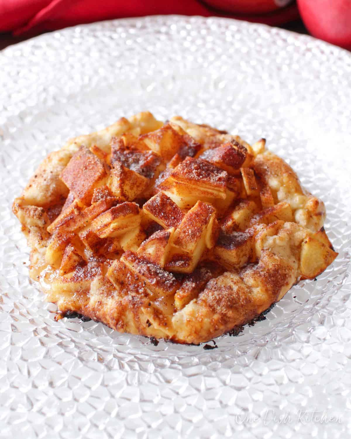 a mini apple galette made with one apple on a white plate.