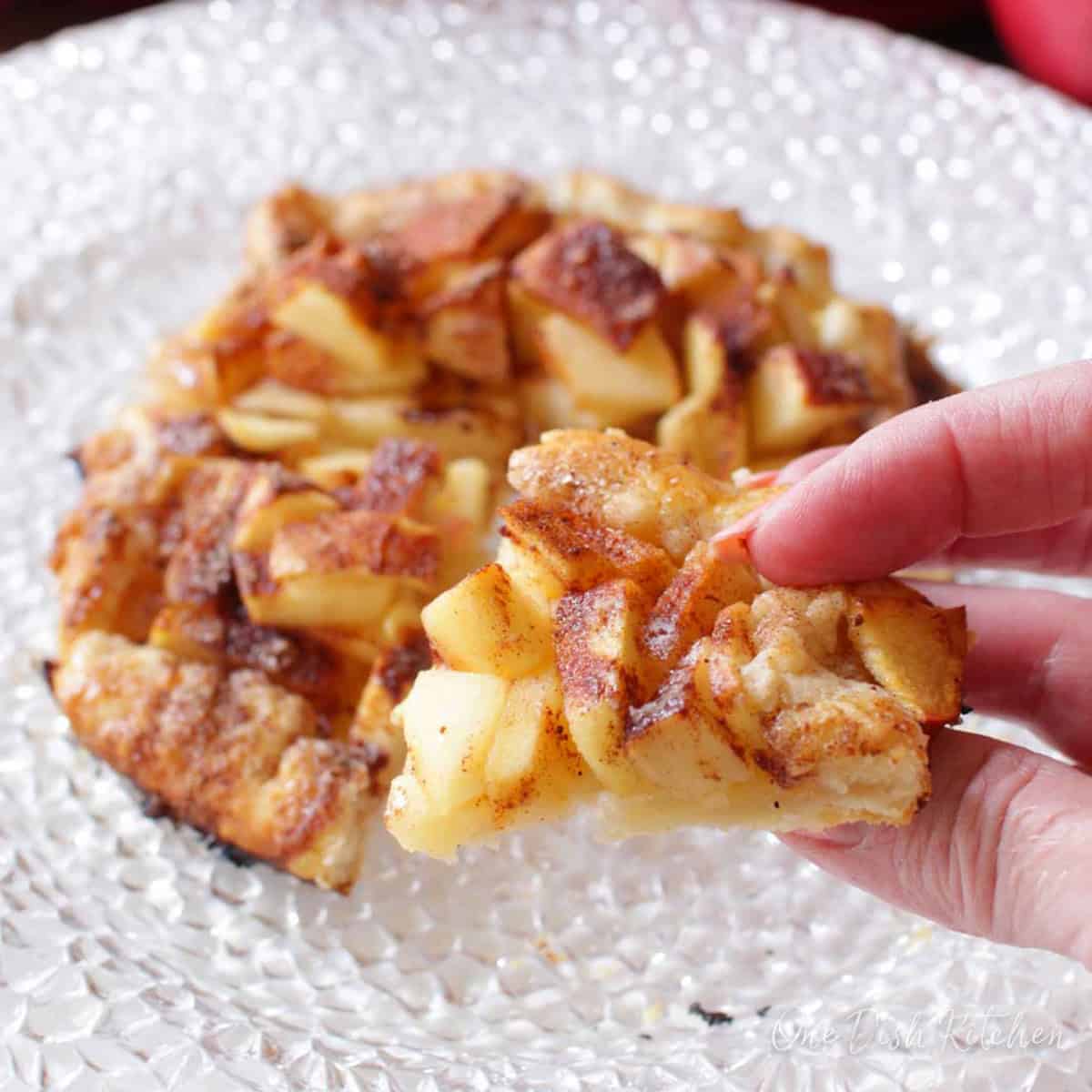 a mini apple galette cut into four pieces on a plate.