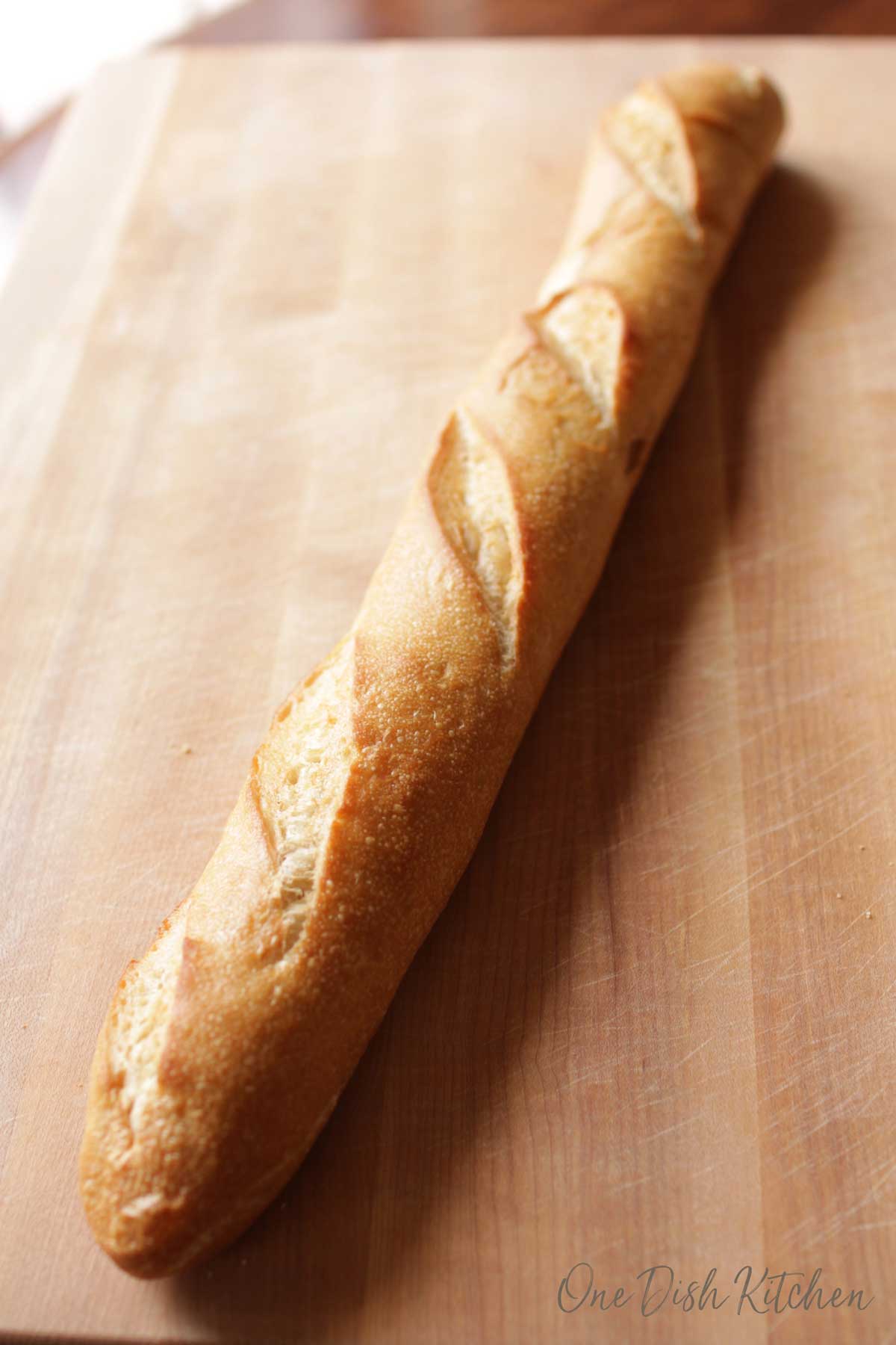 A loaf of french bread on a wooden cutting board