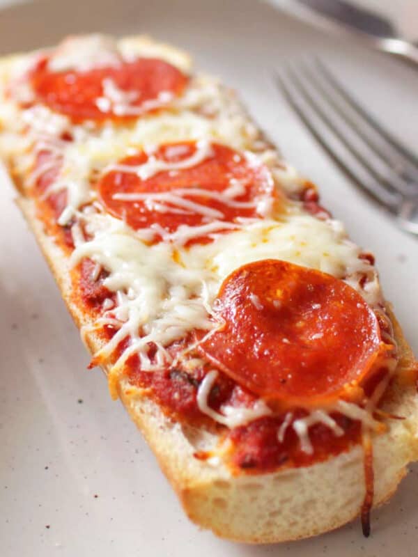 a french bread pizza on a white plate.
