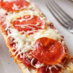 a large piece of french bread topped with sauce, cheese and pepperoni.