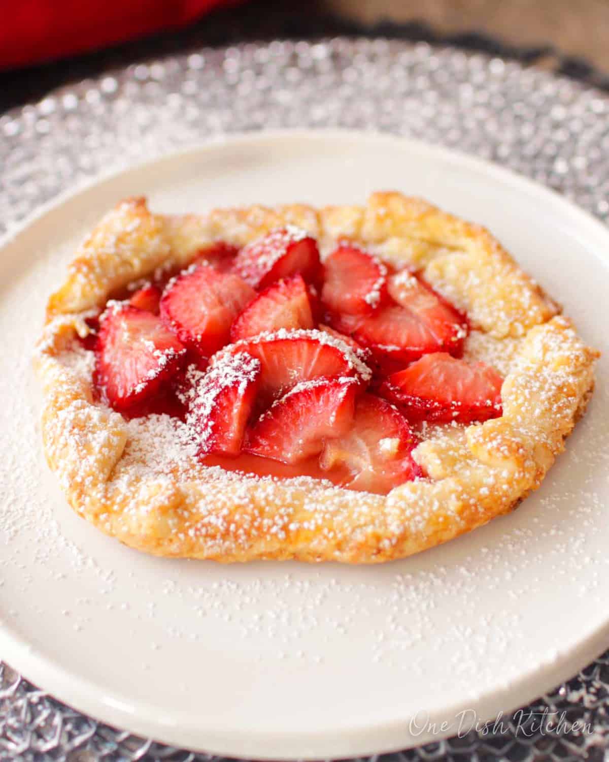 a small strawberry galette made with a mini pie crust and topped with strawberries.
