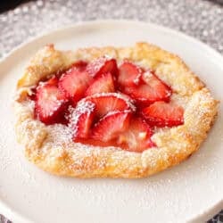 a small strawberry galette made with a mini pie crust and topped with strawberries.