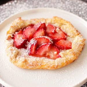 a small strawberry galette made with a mini pie crust and topped with strawberries.