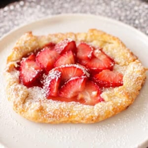 a strawberry galette on a white pie plate.