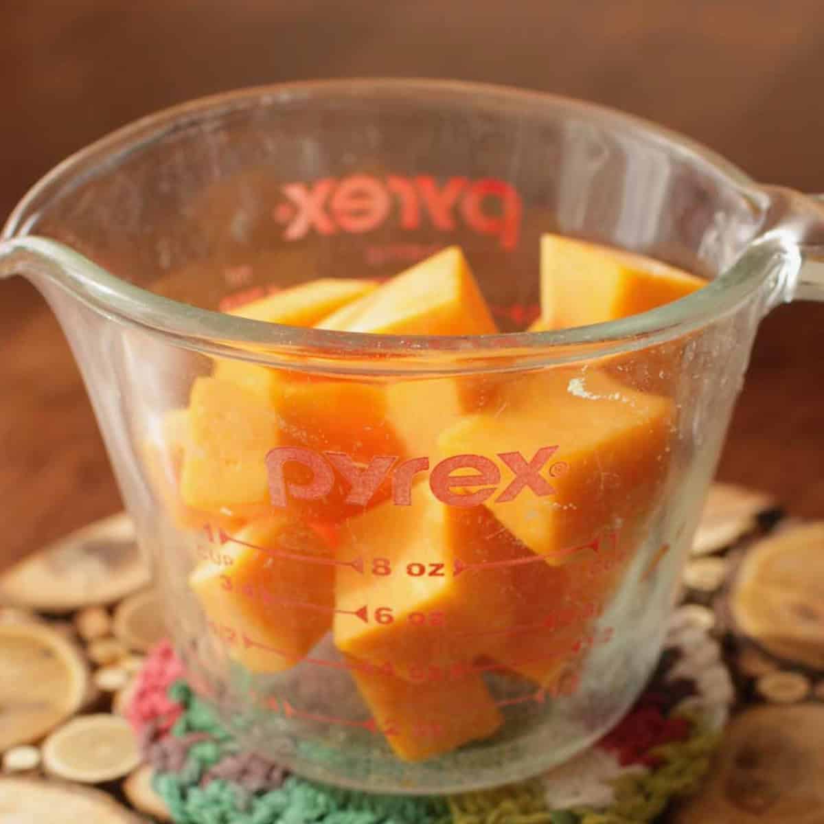 one cup of cubed butternut squash in a small measuring cup.