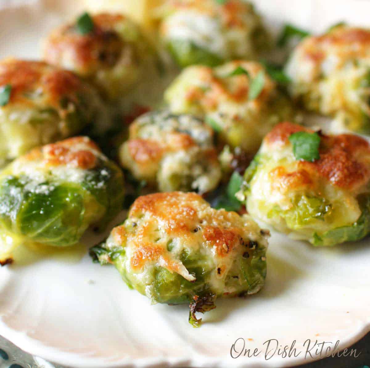 A closeup of a plate of cheesy smashed brussels sprouts.
