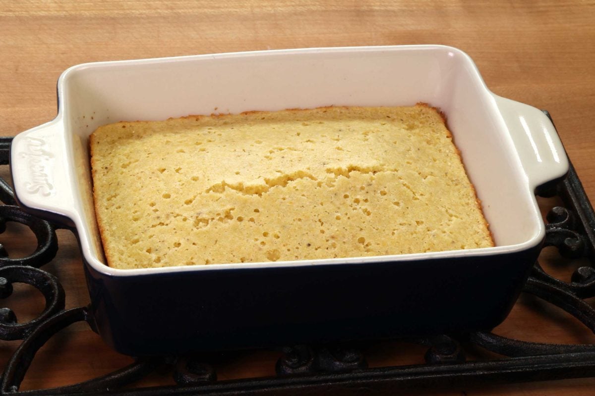 baked cornbread in a rectangular blue baking dish.