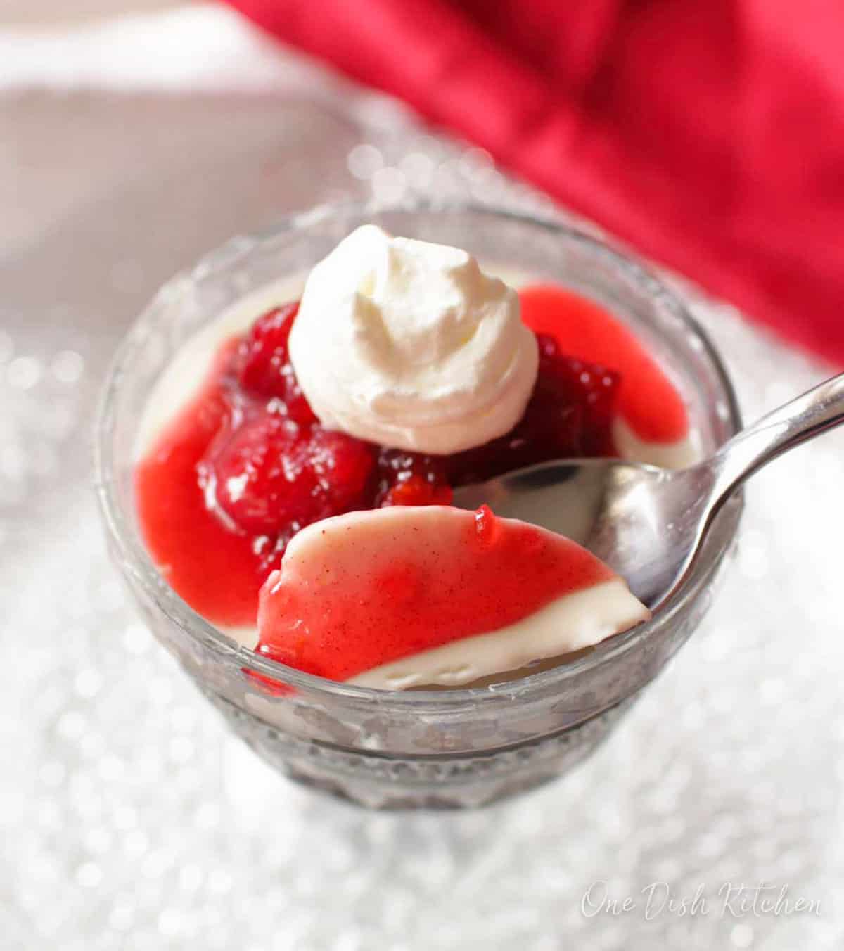 panna cotta in a dessert dish with a spoon on the side.