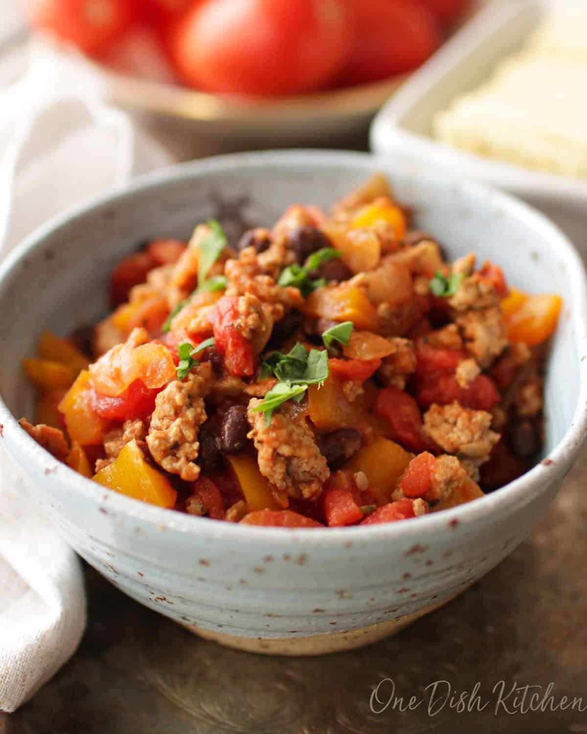a single serving of turkey chili with tomatoes and peppers in a bowl.