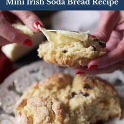 a piece of irish soda bread with butter next to the small loaf of bread on a white plate.