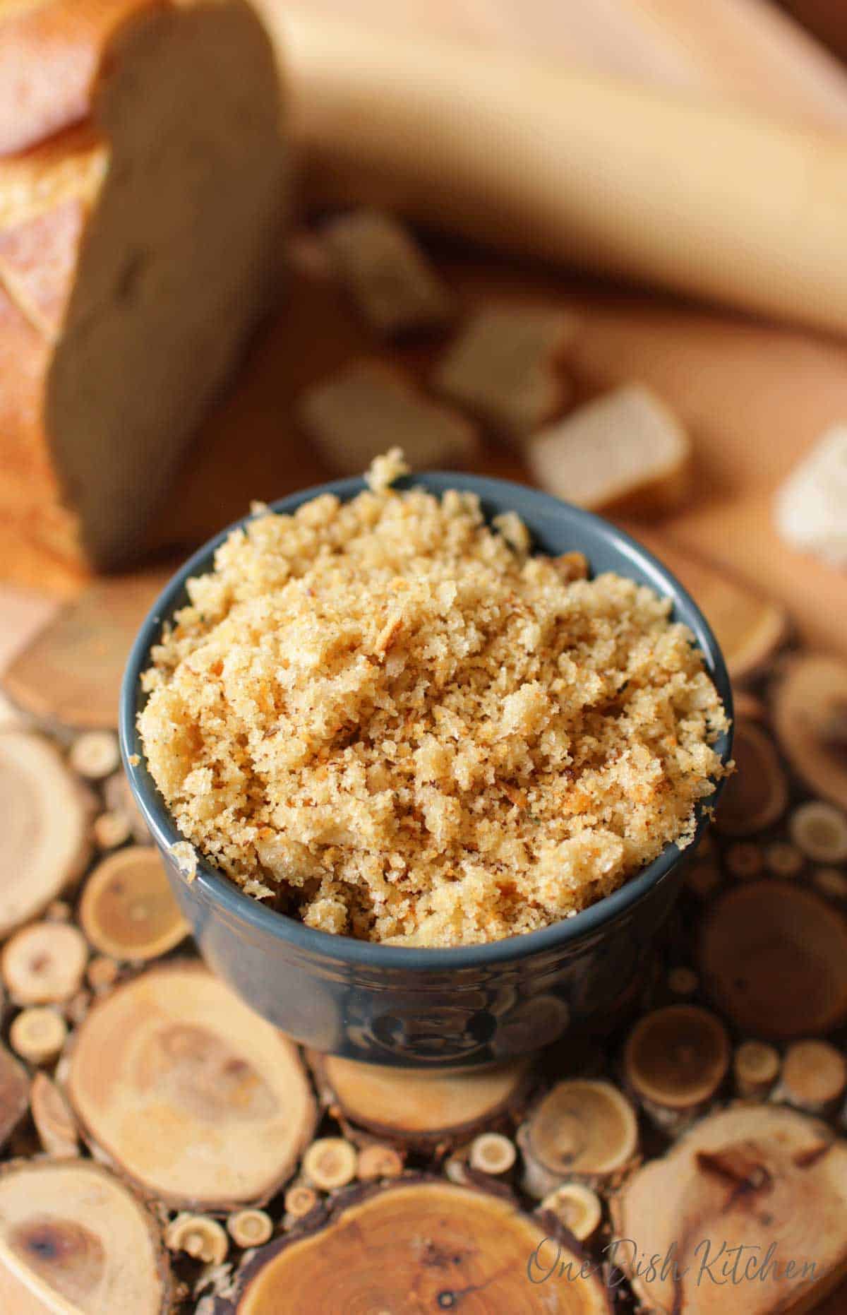 A small bowl of homemade breadcrumbs on a wooden trivet.