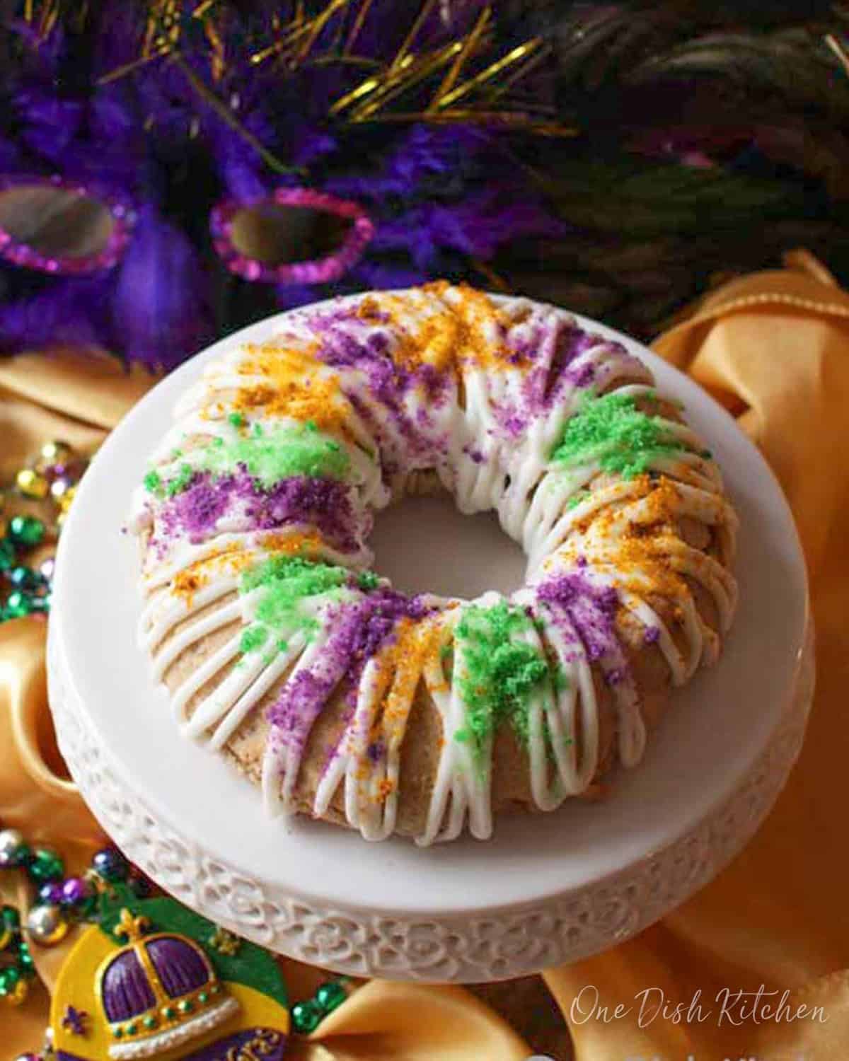 a king cake scone topped with glaze and colored sugar the colors of mardi gras.