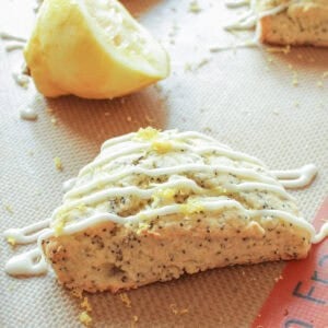 a lemon scone with a glaze on a baking sheet.