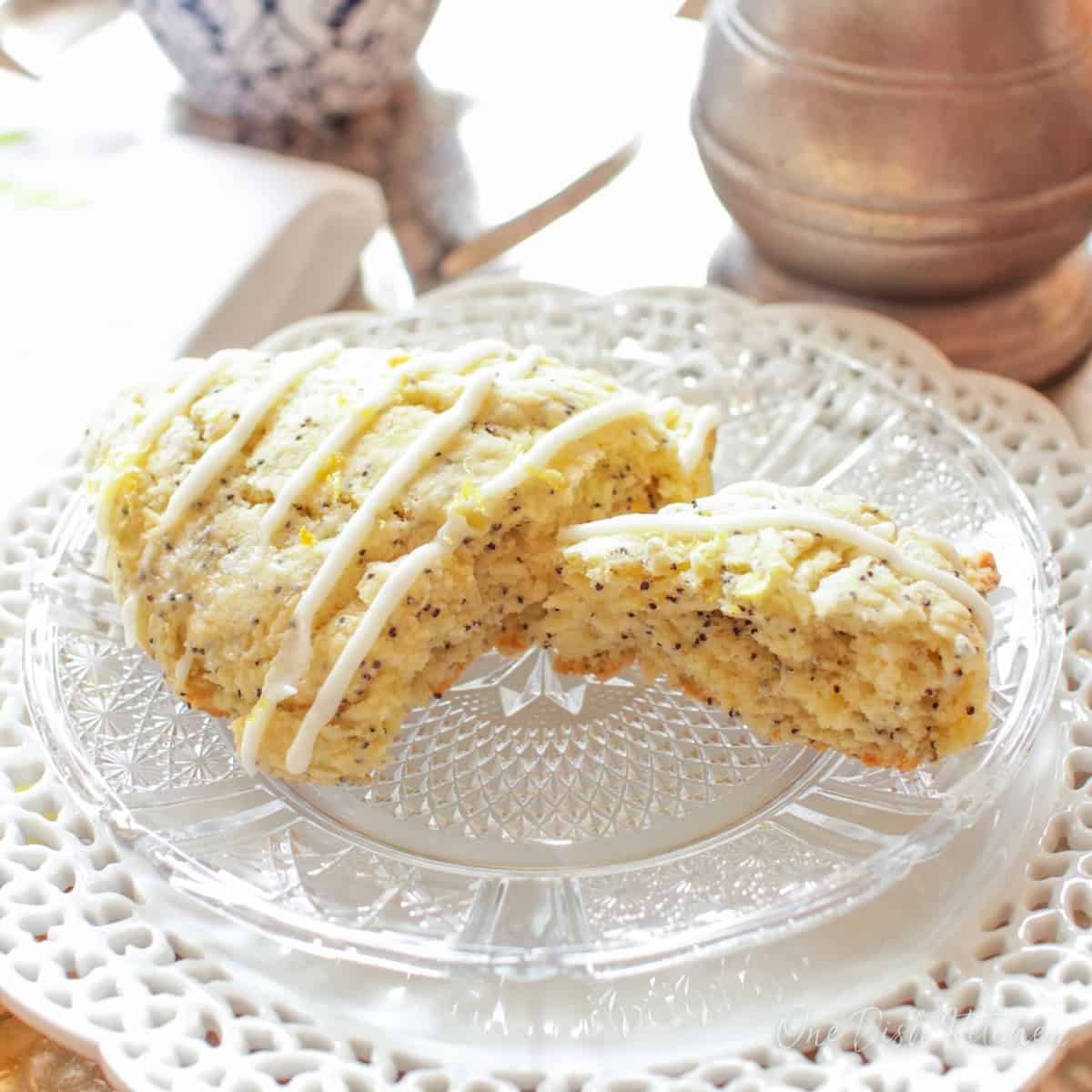 a scone sliced in half on a plate next to a cup of coffee.