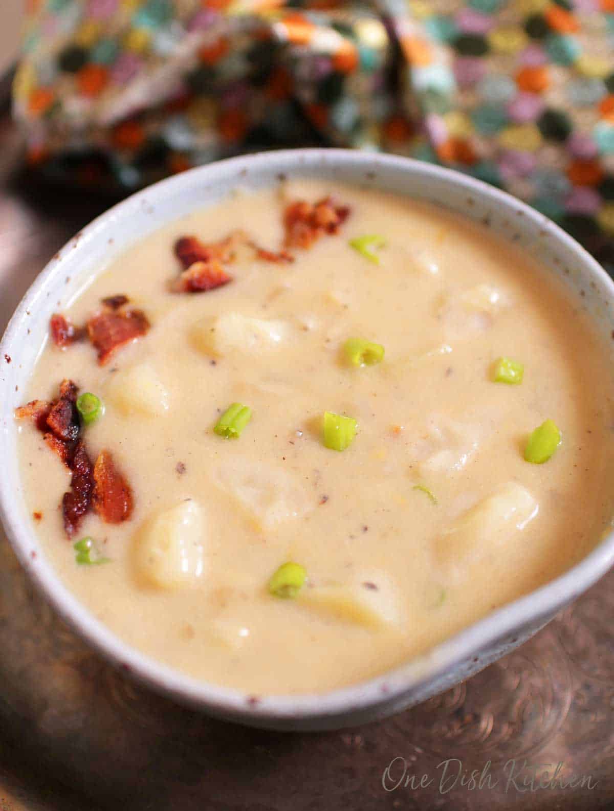 Closeup of potato soup topped with chopped bacon in a bowl.