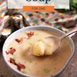 a bowl of potato soup with a spoon on the side.