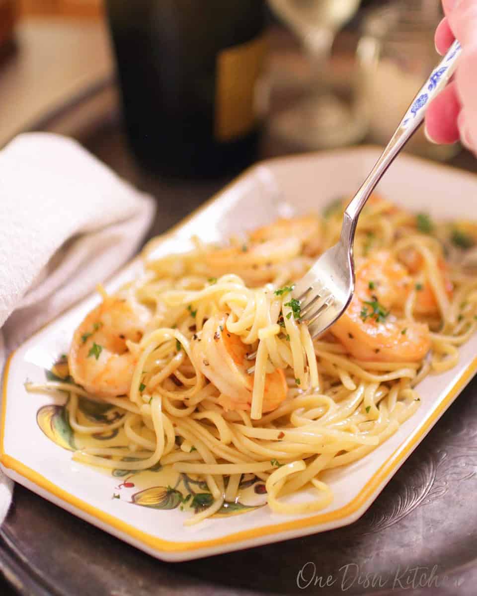 a plate of shrimp scampi with a fork on the side.