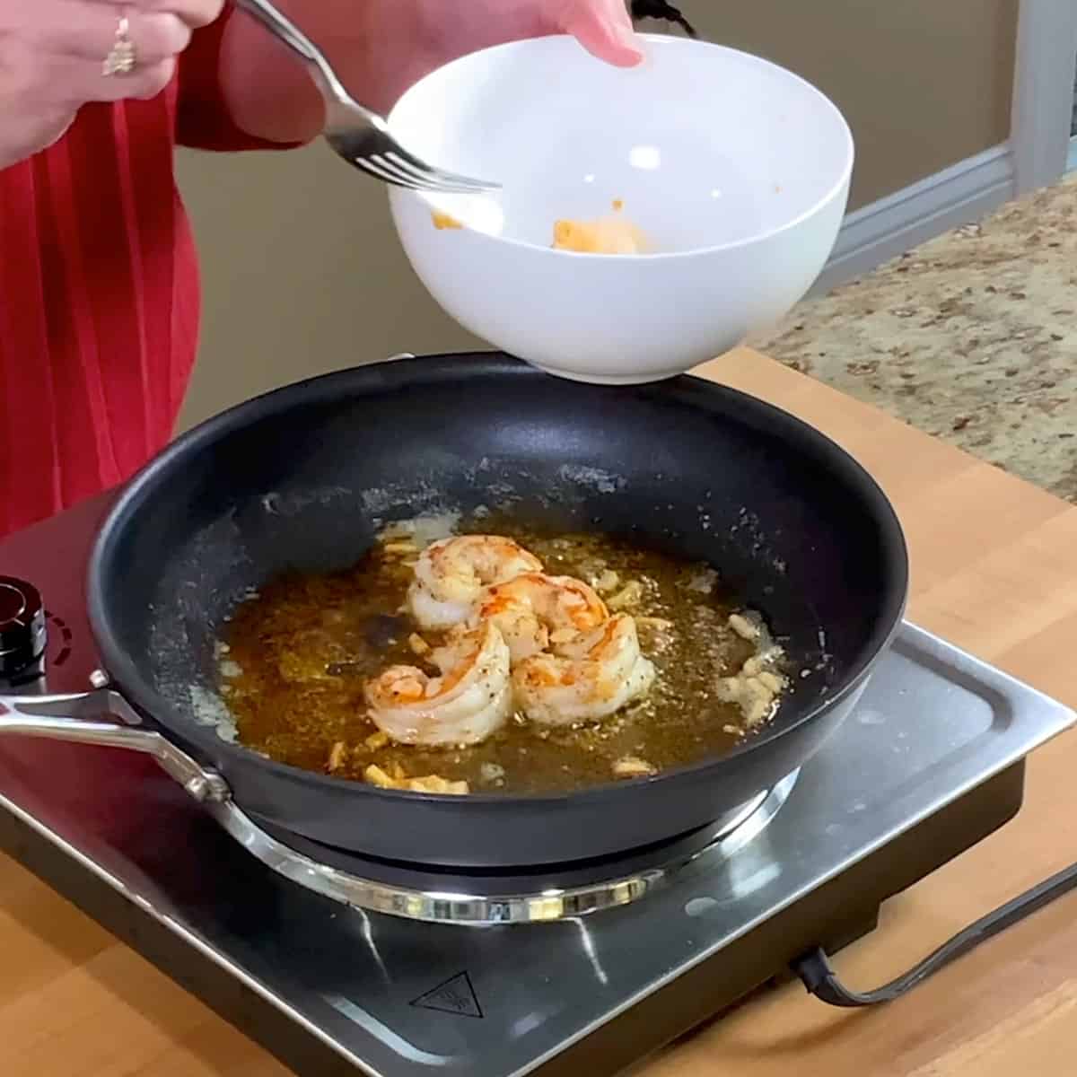 5 shrimp cooking in a pan