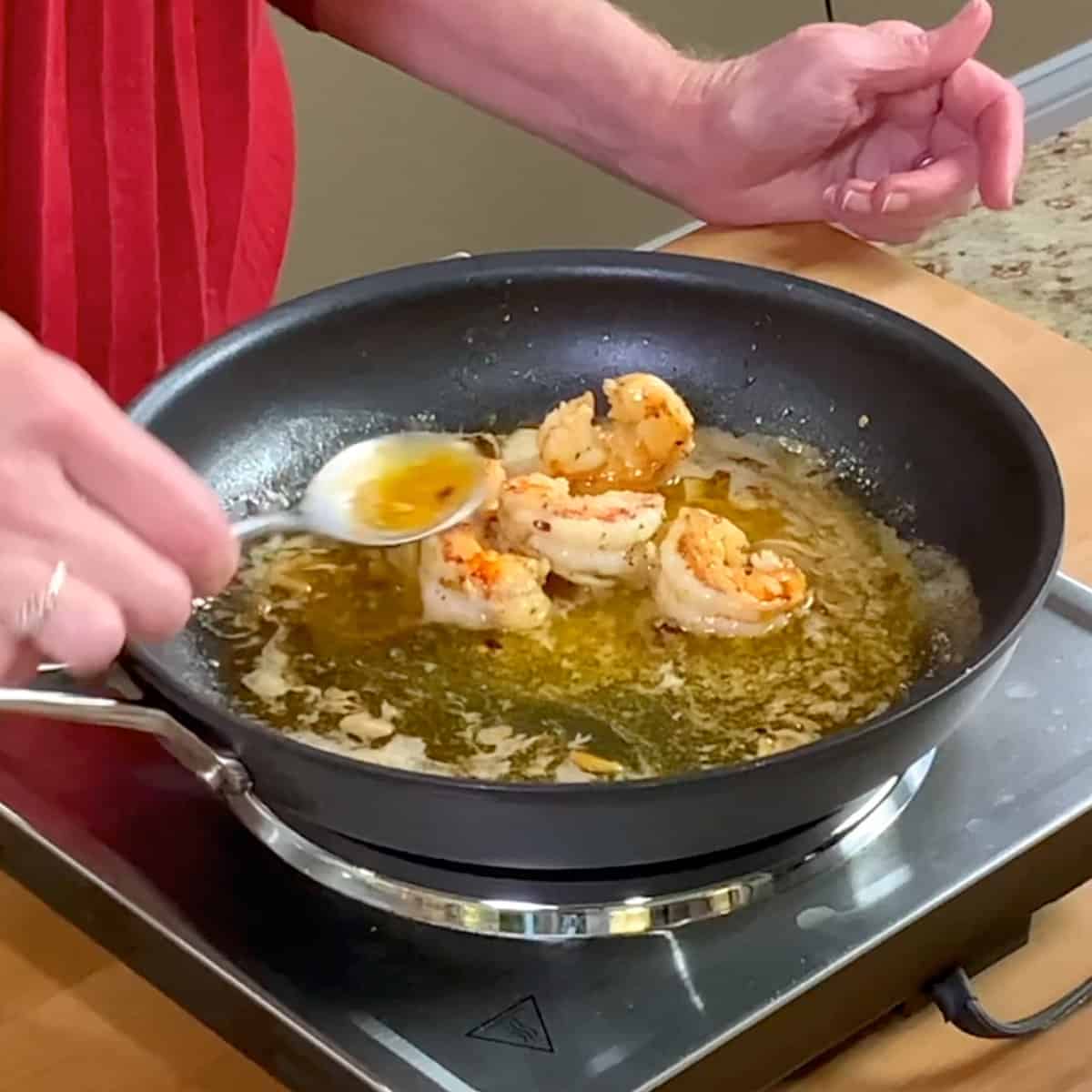 shrimp cooking in a butter sauce in a skillet