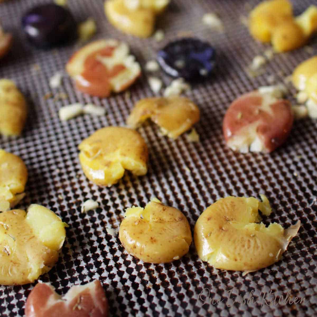 smashing potatoes on a baking sheet with the bottom of a drinking glass.