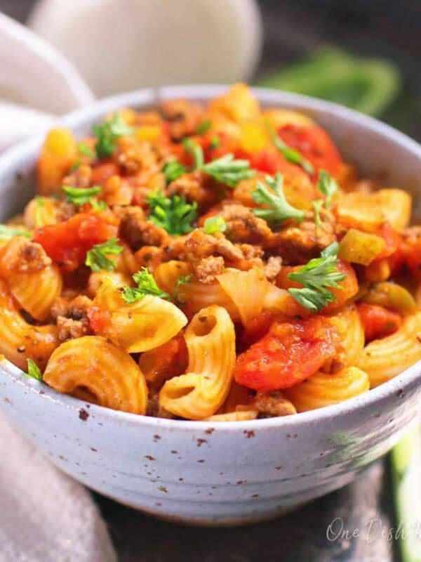 A bowl of american goulash topped with fresh parsley.