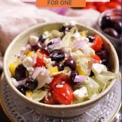 greek salad in a bowl on a silver tray.