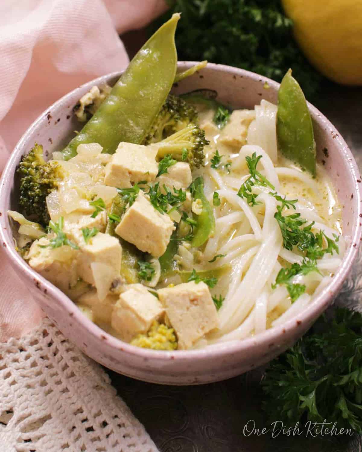 a bowl of green curry with tofu.