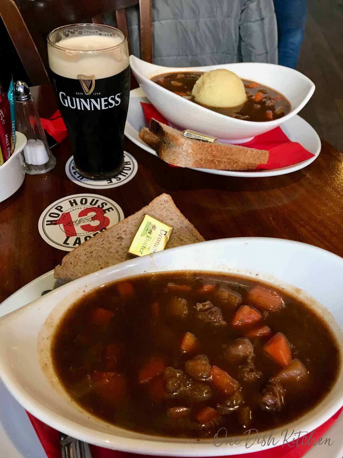 Enjoying two bowls of irish stew in a pub in dublin with a glass of Guinness.