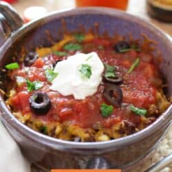 a small taco casserole topped with sour cream and olives.