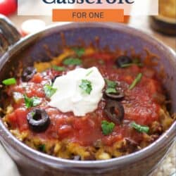 a small taco casserole topped with sour cream and olives.