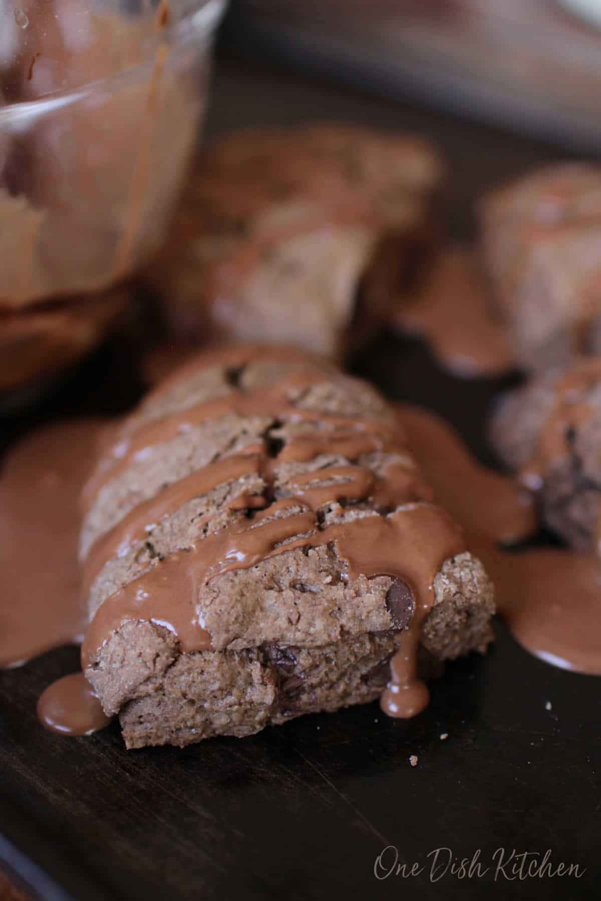 A closeup of a chocolate scone covered with chocolate glaze.