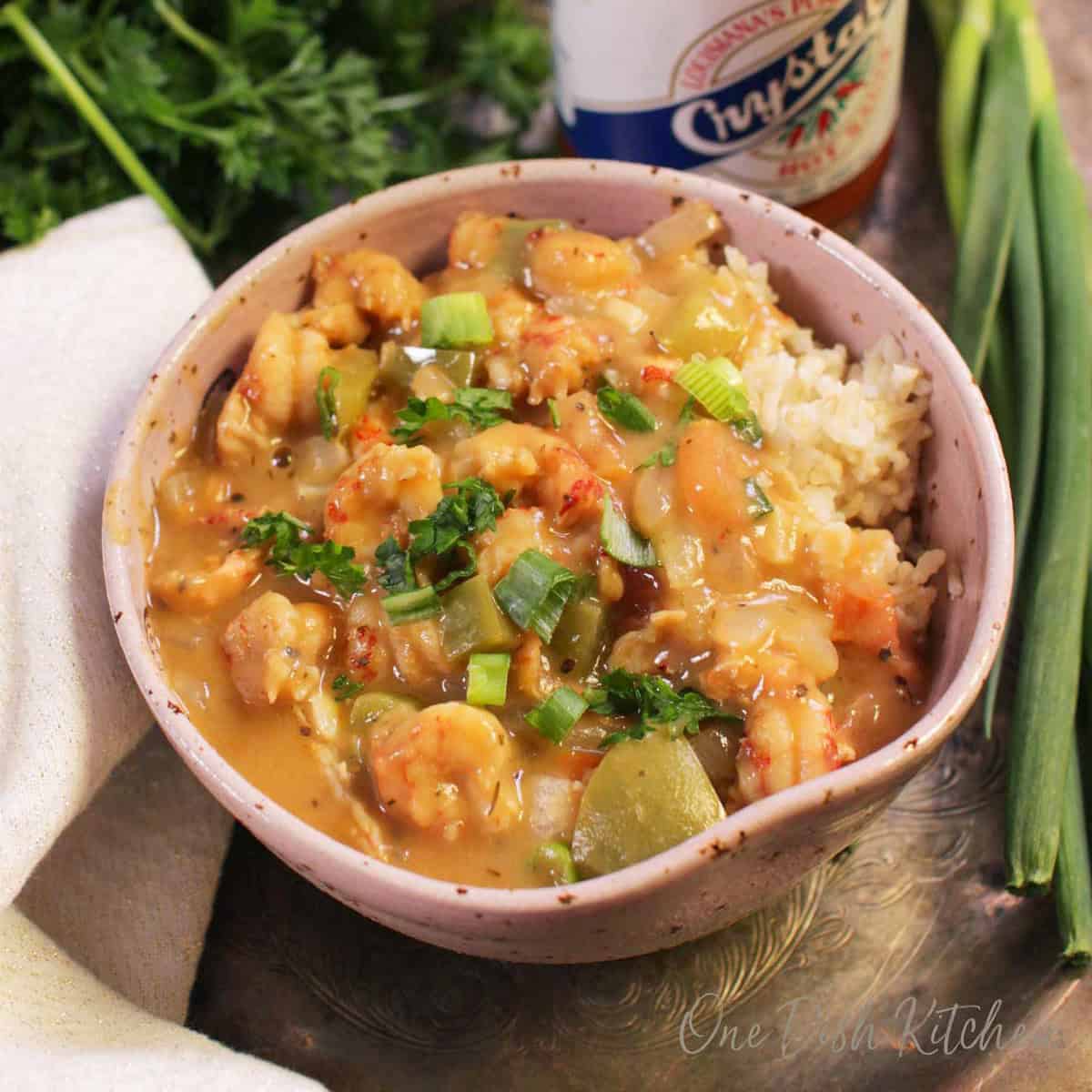 a single serving of crawfish etouffee in a bowl served over white rice.