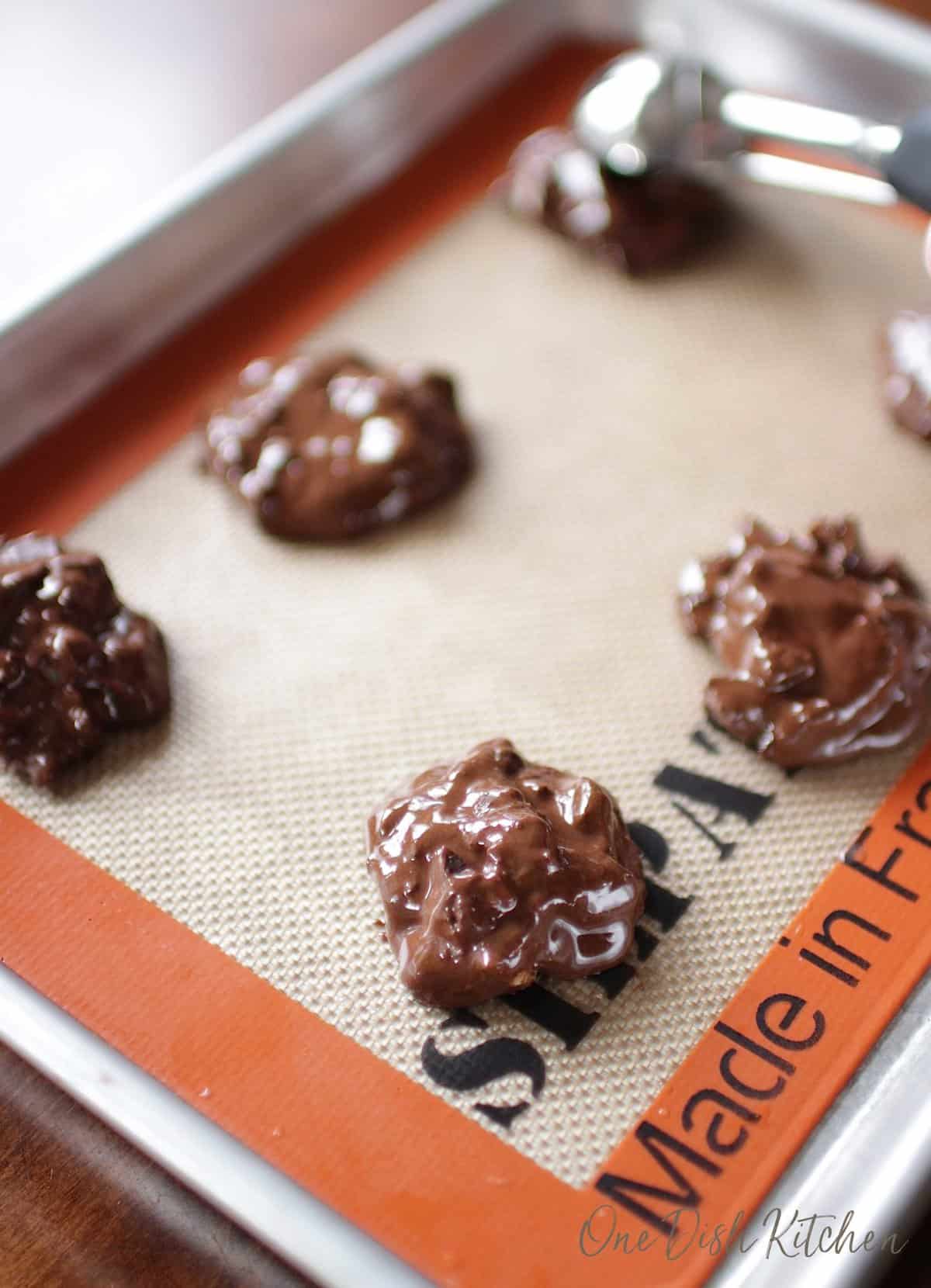 unbaked flourless chocolate cookies on a baking sheet.