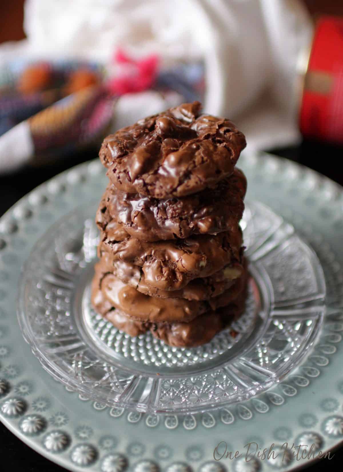 Six flourless chocolate cookies stacked on top of each other on a plate