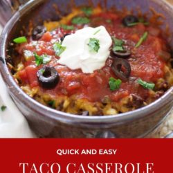 a taco casserole in a purple bowl topped with sour cream and sliced olives.