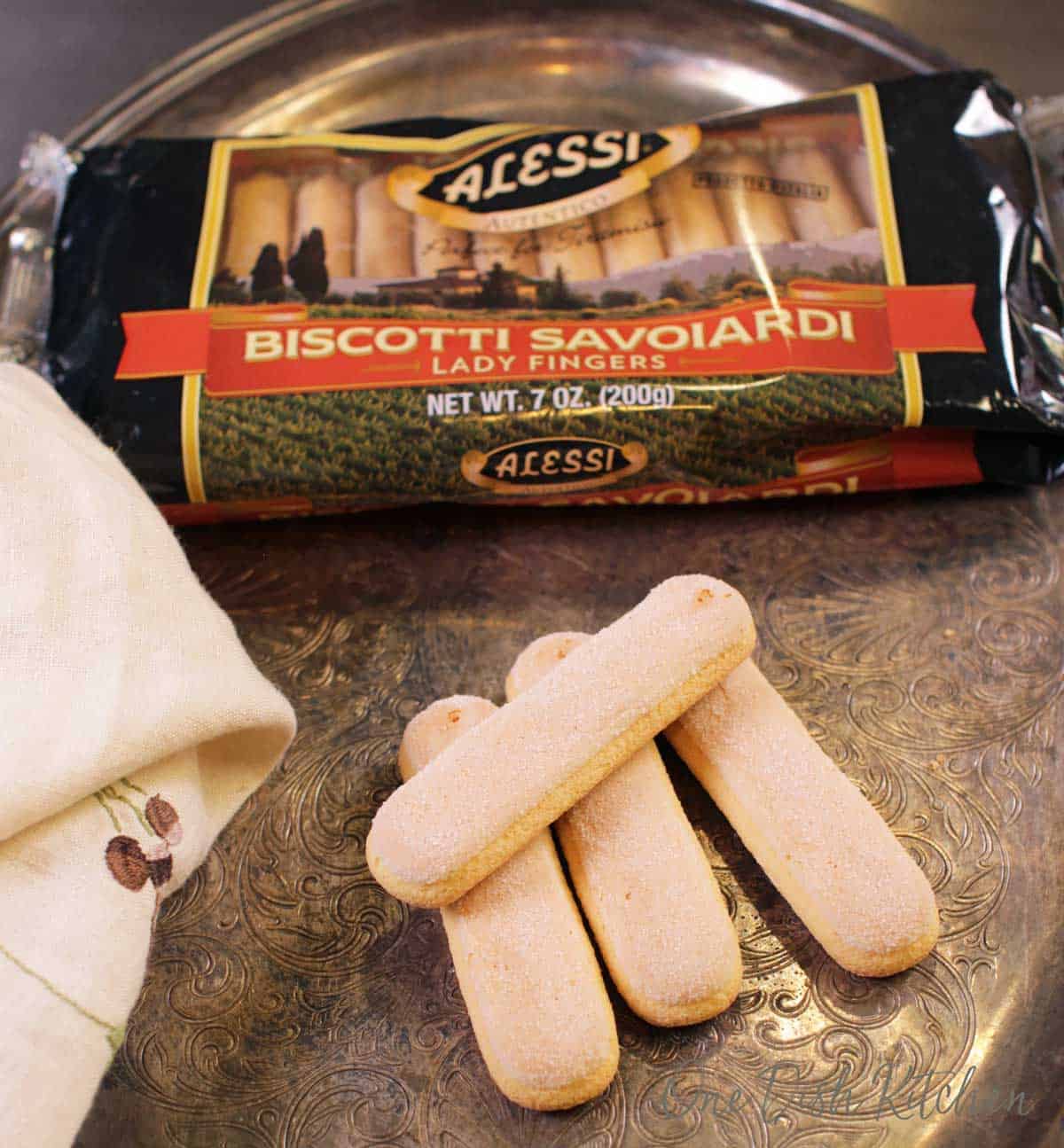 Biscotti Savoiardi package next to four lady fingers on a metal tray.
