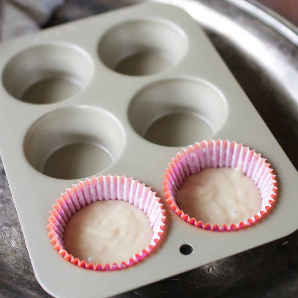 Two unbaked cupcakes in a cupcake tin.