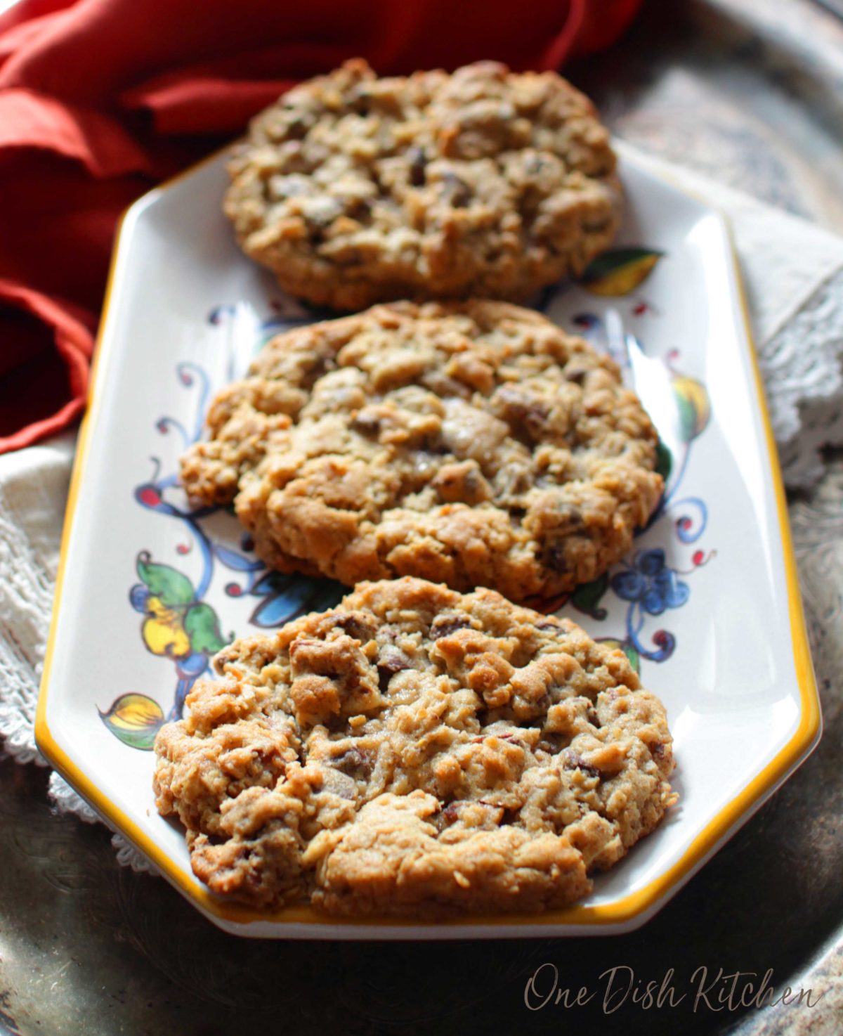 Three large cowboy cookies on a plate.