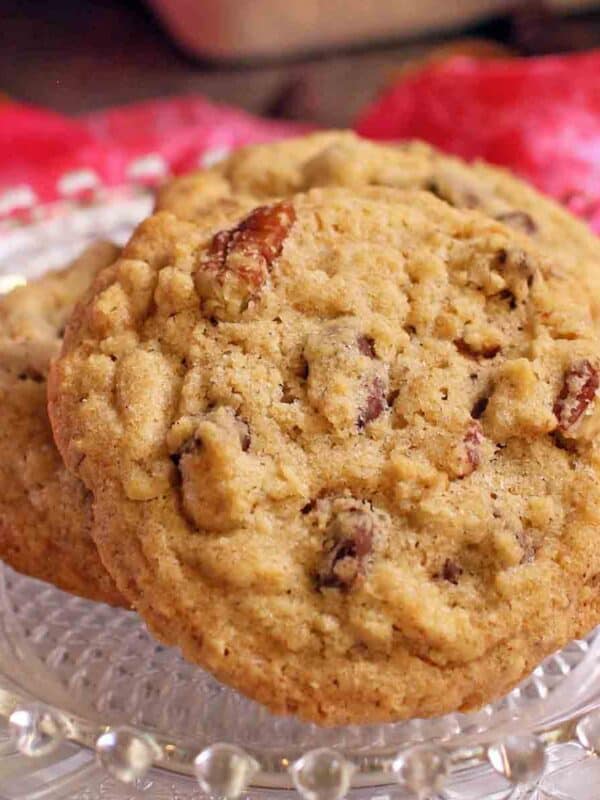 a plate with three doubletree chocolate chip cookies on it next to a bright pink napkin.