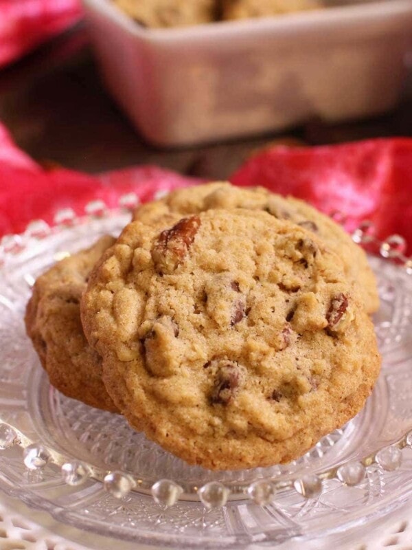 a plate with three doubletree chocolate chip cookies on it next to a bright pink napkin.