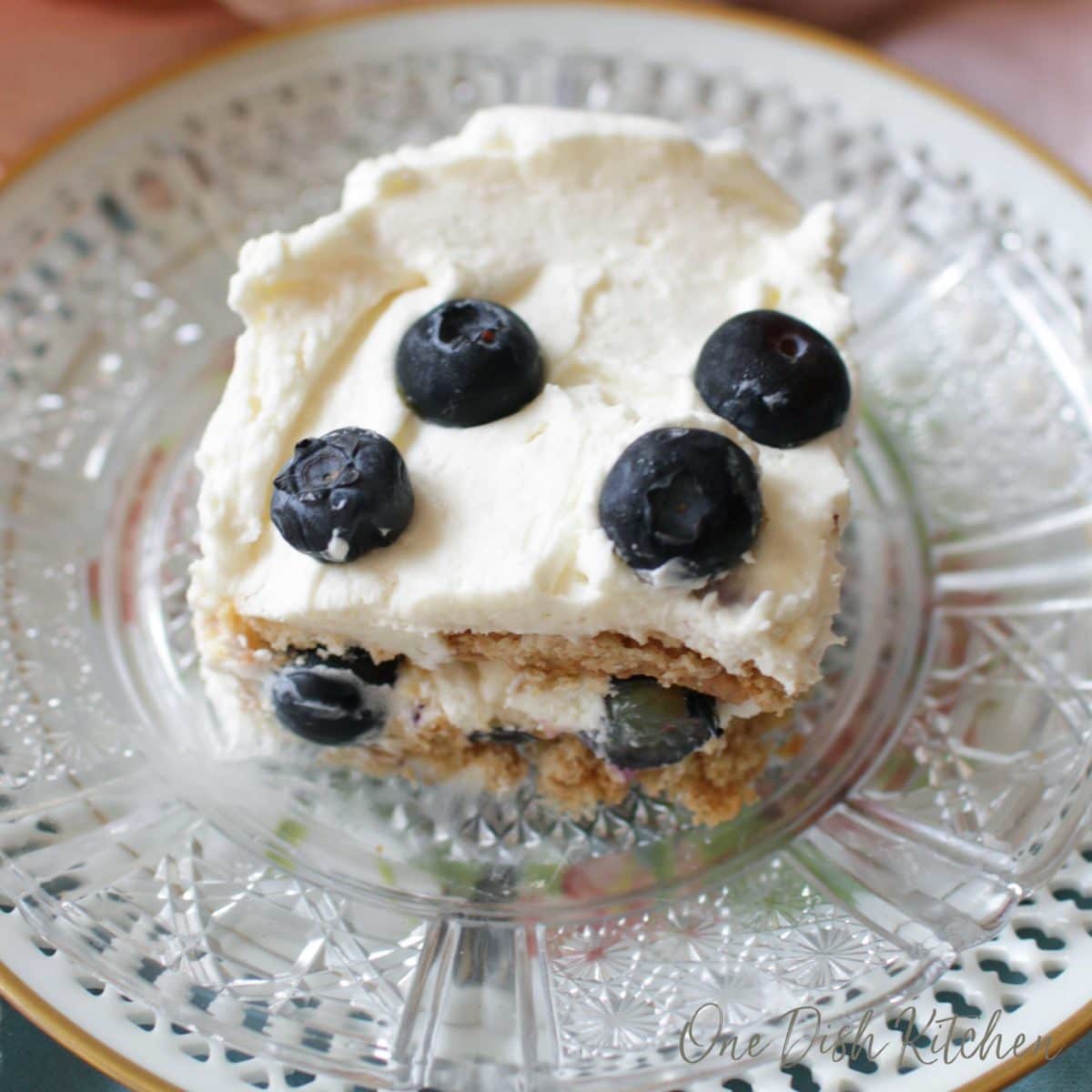 An overhead view of a slice of icebox cake topped with blueberries on a plate
